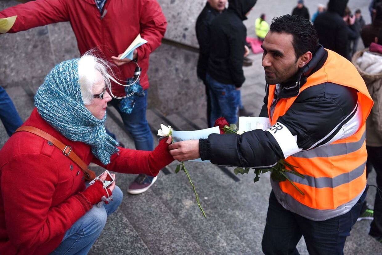 Flygtninge fra Syrien gav blomster til forbipasserende under lørdagens demonstration mod episoden nytårsaften ved byens hovedbanegård.