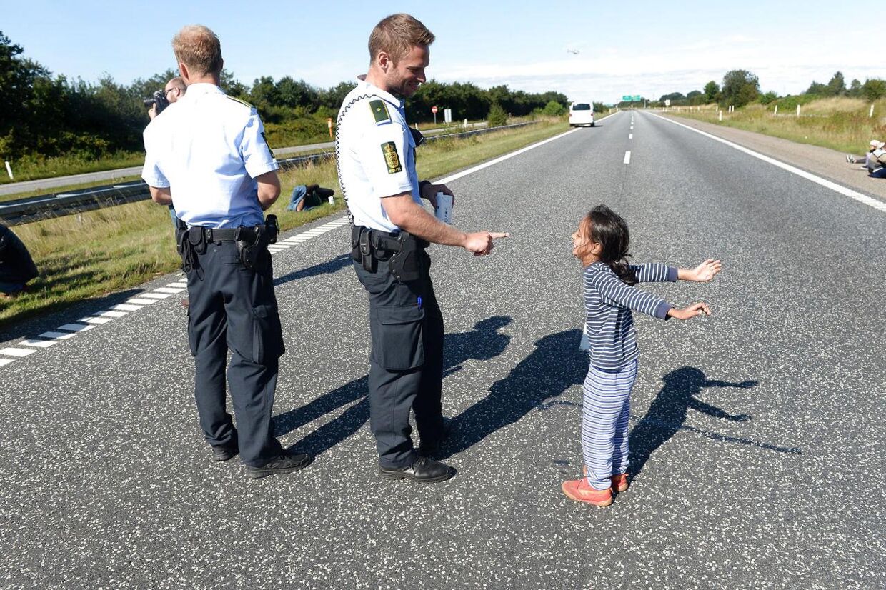 Den jyske betjent leger med den syriske pige under vandringen på Sønderjyske Motorvej onsdag.