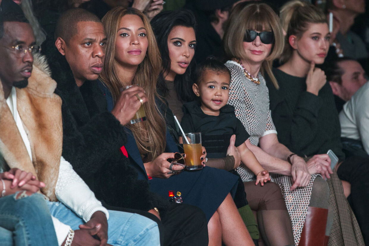 Kim Kardashian med sin datter North West på skødet, på første række, under Kanye Wests efterår/vinter 2015 modeshow i samarbejde med Adidas under modeugen i New York. Til højre ses den legedariske moderedaktør for det amerikanske Vogue Anna Wintour. Og til venstre for Kim kardashian har hun Beyonce og Jay-Z og Sean Combs (P-Diddy).&nbsp;&nbsp;