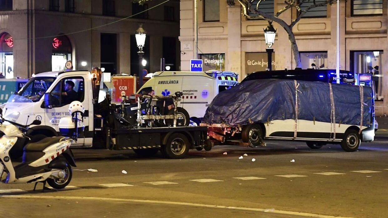 The van who ploughed into the crowd, killing at least 13 people and injuring around 100 others is towed away from the Rambla in Barcelona on August 18, 2017. A driver deliberately rammed a van into a crowd on Barcelona's most popular street on August 17, 2017 killing at least 13 people before fleeing to a nearby bar, police said. Officers in Spain's second-largest city said the ramming on Las Ramblas was a "terrorist attack". The driver of a van that mowed into a packed street in Barcelona is still on the run, Spanish police said. / AFP PHOTO / JAVIER SORIANO