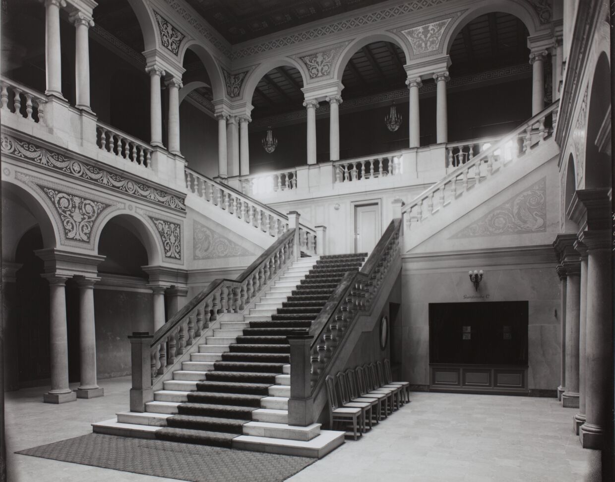 Den nuværende Palads-bygning stod færdig som biograf i 1918 og er tegnet af arkitekterne Andreas Clemmesen og Johan Nielsen, som opførte den i nybarok stil. Foyeren er centret omkring den imponerende trappe i italiensk renæssancestil. Billedet her er fra ca. 1919.