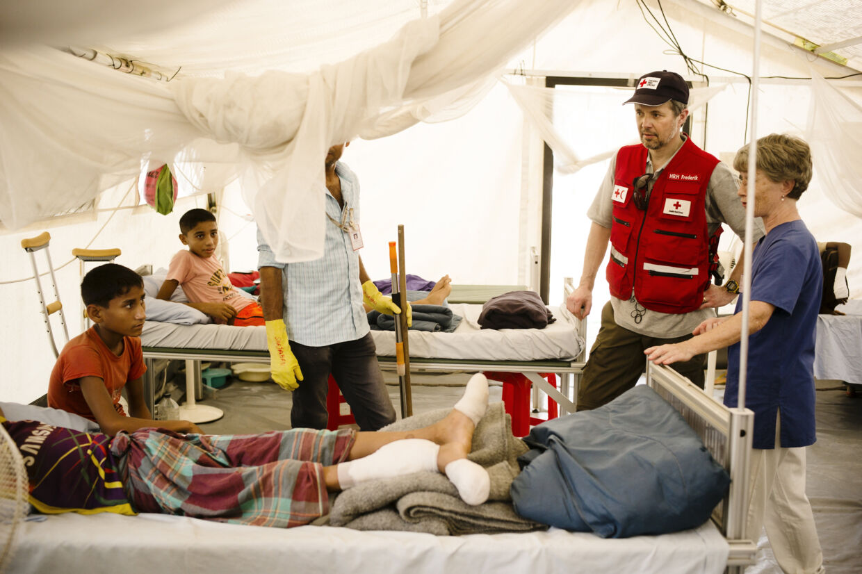 Kronprins Frederik taler med to drenge, som er indlagt på Røde Kors felthospital med brækkede ben, i verdens største flygtningelejr ved Coxs Bazar i Bangladesh. Skaderne er opstået ved fald på de stejle skråninger i lejren. Med monsunregnens komme frygter Røde Kors&#039; læger og sygeplejersker, at mange flere vil komme til skade. Scanpix/Jakob Dall/røde Kors