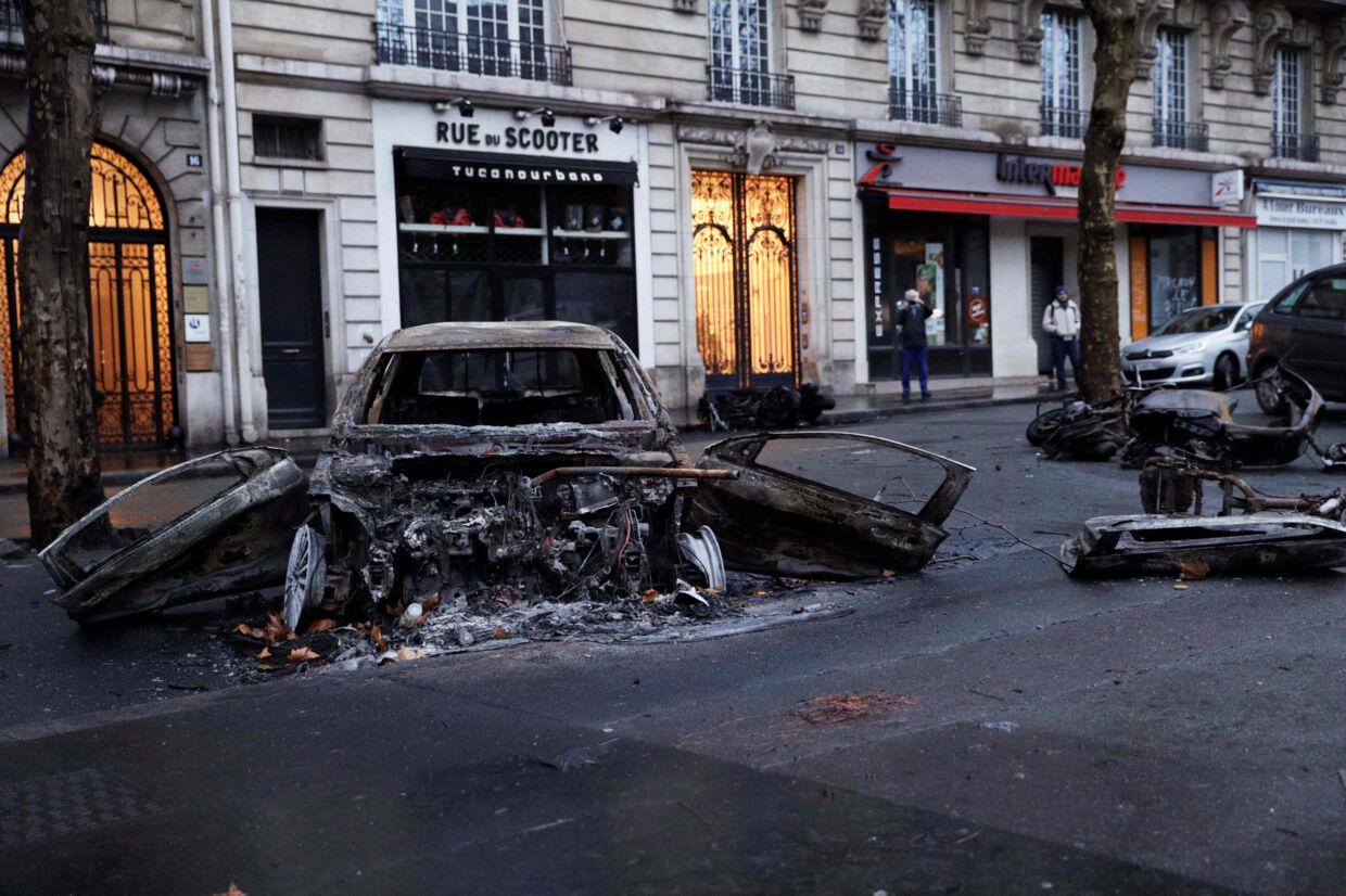 Søndag morgen stod udbrændte biler tilbage i gaderne i Paris, der var præget af voldsomme gadekampe lørdag aften. Geoffroy Van Der Hasselt/Ritzau Scanpix