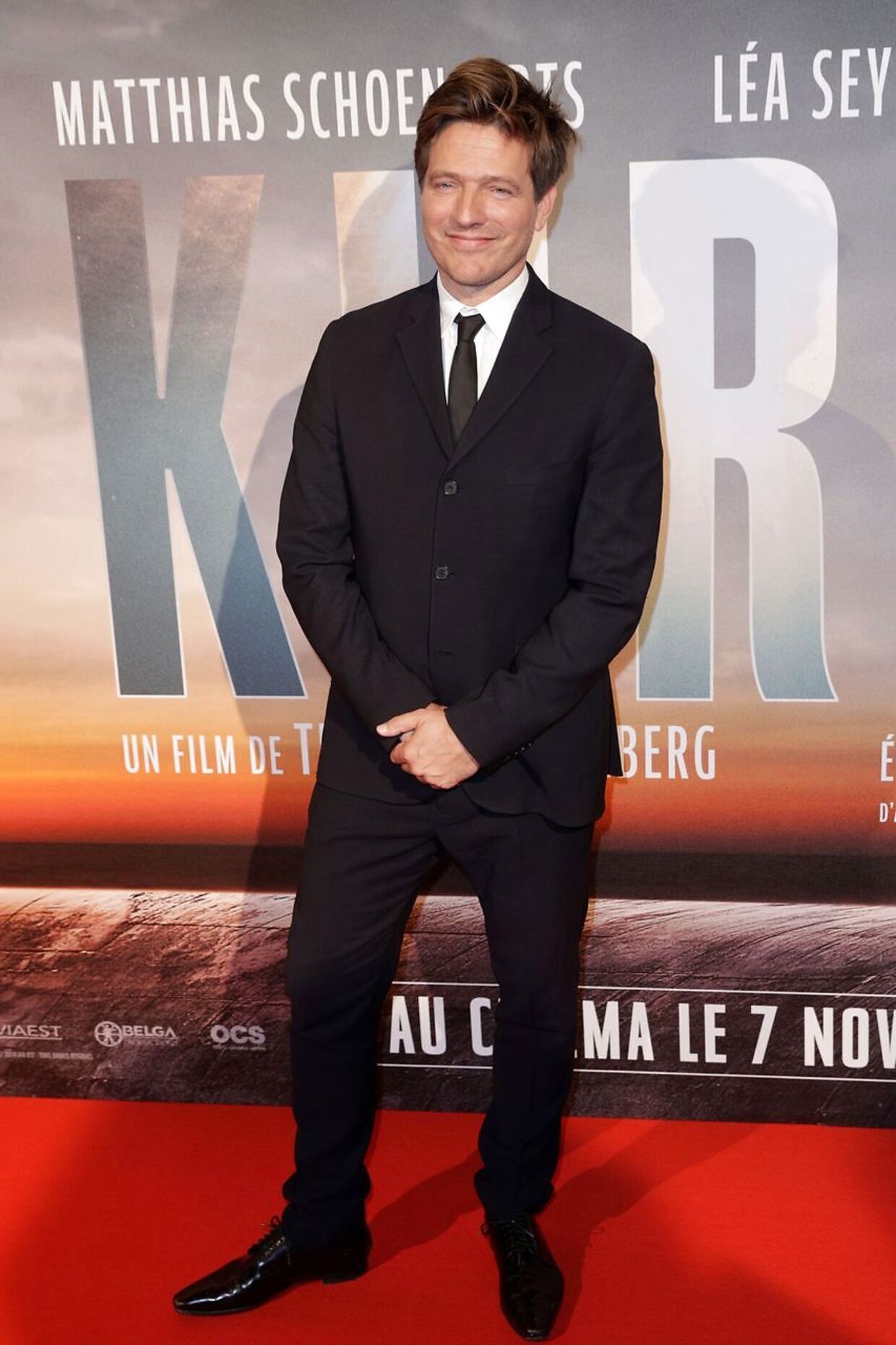 Thomas Vinterberg poserer foran Kursk-filmplakaten.