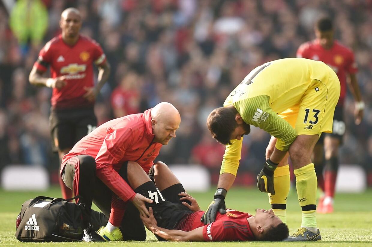 Manchester United's English midfielder Jesse Lingard (C) gets attention on the pitch for an injury before being substituted during the English Premier League football match between Manchester United and Liverpool at Old Trafford in Manchester, north west England, on February 24, 2019. (Photo by Oli SCARFF / AFP) / RESTRICTED TO EDITORIAL USE.No use with unauthorized audio, video, data, fixture lists, club/league logos or 'live' services. Online in-match use limited to 120 images. An additional 40 images may be used in extra time.No video emulation. Social media in-match use limited to 120 images. An additional 40 images may be used in extra time.No use in betting publications, games or single club/league/player publications. /