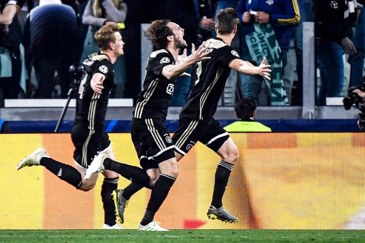 Ajax's Dutch defender Matthijs de Ligt (L) celebrates with Ajax's Dutch defender Daley Blind (C) after scoring his team's second goal during the UEFA Champions League quarter-final second leg football match Juventus vs Ajax Amsterdam on April 16, 2019 at the Juventus stadium in Turin. (Photo by Filippo MONTEFORTE / AFP)