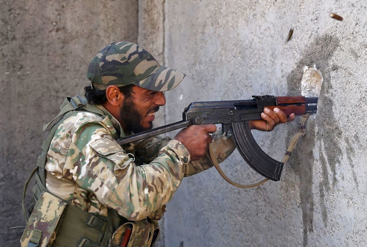 A Turkish-backed Syrian fighter grimaces as he fires his rifle on enemy positions, in Syria's northeastern town of Ras al-Ain in the Hasakeh province along the Turkish border as Turkey and its allies continue their assault on Kurdish-held border towns in northeastern Syria. - Ras al-Ain, is the main remaining flashpoint along the border where Kurdish-led SDF have been putting up stiff resistance against Turkish air strikes and shelling for almost a week. (Photo by Nazeer Al-khatib / AFP)