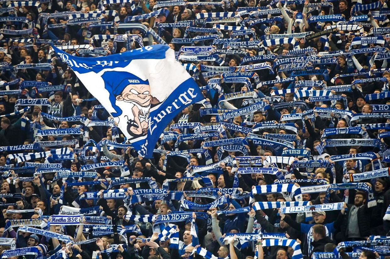 (FILES) In this file photo taken on November 02, 2017 Hertha Berlin's fans cheer up their team during the UEFA Europa League football match between Hertha BSC Berlin and FC Zorya Luhansk. - Three decades after the fall of the Berlin Wall, the German capital's FC Union and Hertha Berlin will meet for their first Bundesliga derby, with fans wondering if a real rivalry will grow or if the spirit of reunification will prevail. (Photo by Odd ANDERSEN / AFP)