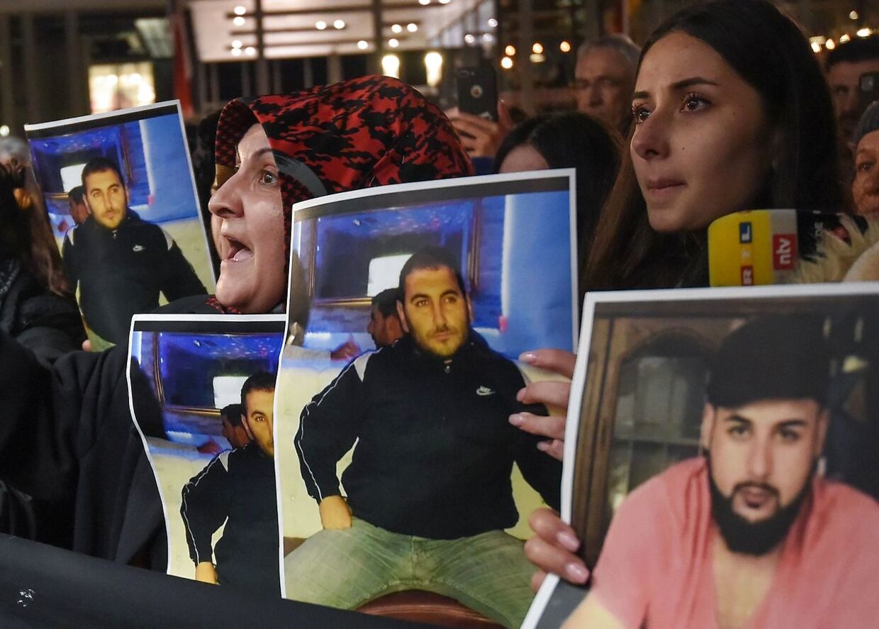 Sørgende familiemedlemmer viser billeder af to af de dræbte ved en demonstration foran gerningsstedet i Hanau.