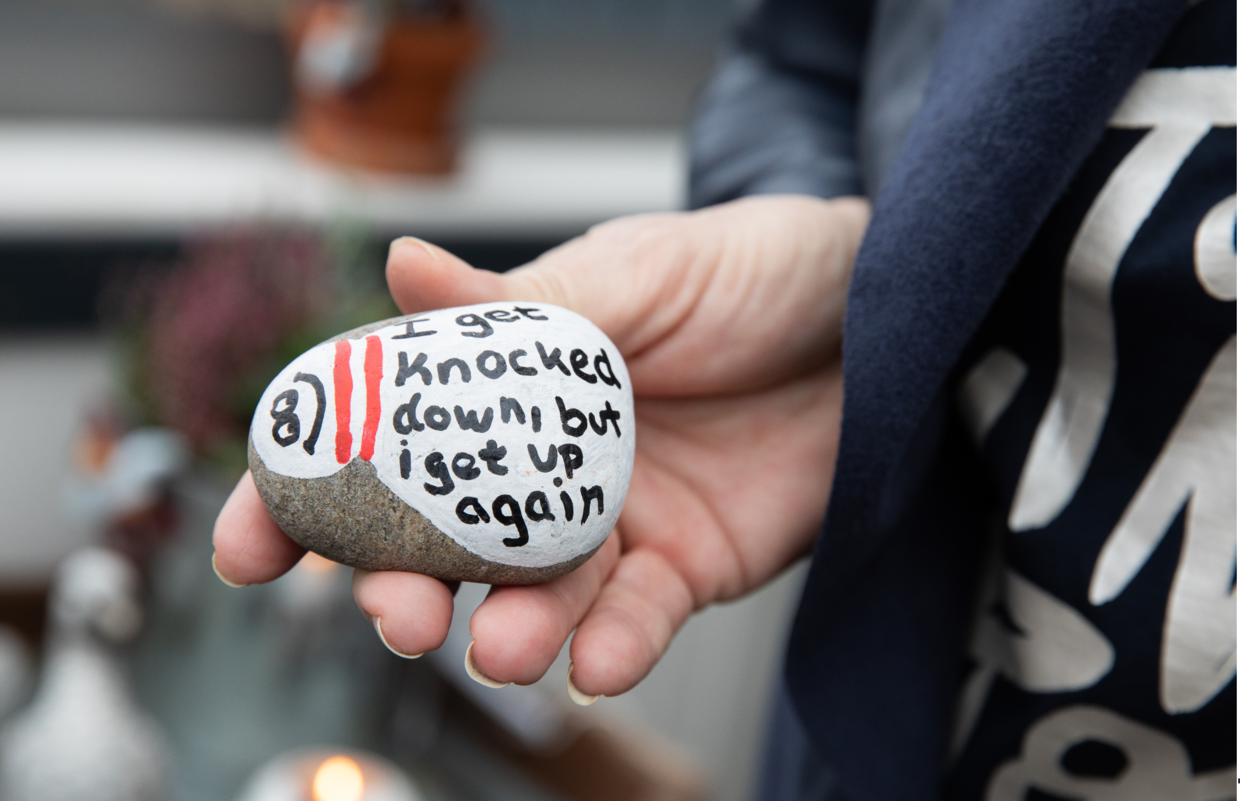 En sten, som et af Dunja Fogelberg Hansens børn har skrevet på til deres kræftsyge mor. 'I get knocked down, but I get up again,' står der. Foto: Jacob Crawfurd/Byrd&nbsp;