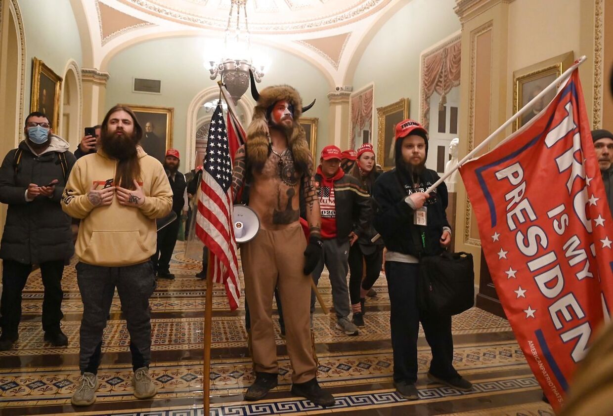 Den åskaldte Q-shaman Jake Angeli (i midten med horn) var blandt de demonstranter, der stormede Kongressen 6. januar. 