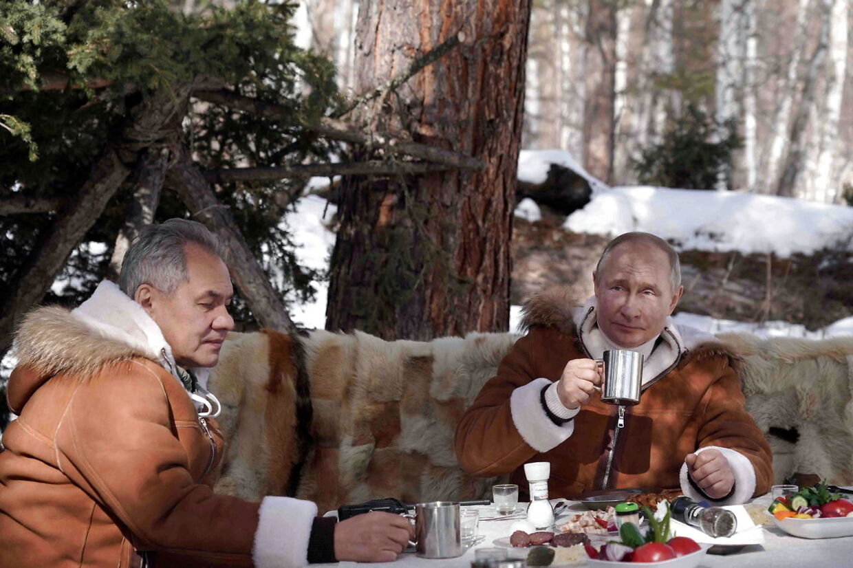 Her ses Vladimir Putin og hans forsvarsminister spise ude i det fri.