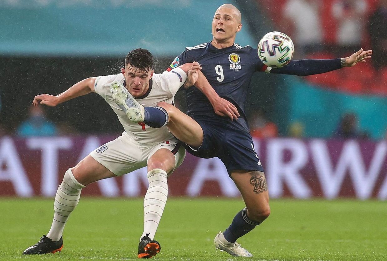 England's midfielder Declan Rice (L) fights for the ball with Scotland's forward Lyndon Dykes during the UEFA EURO 2020 Group D football match between England and Scotland at Wembley Stadium in London on June 18, 2021. (Photo by CARL RECINE / POOL / AFP)