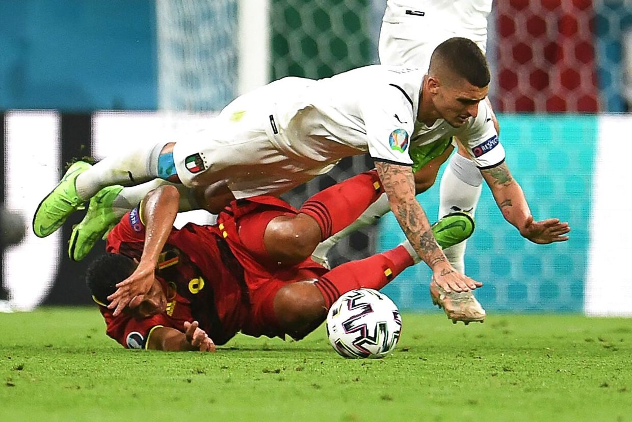 Italy's midfielder Marco Verratti (top) fouls Belgium's midfielder Youri Tielemans (bottom) to earn a yellow card during the UEFA EURO 2020 quarter-final football match between Belgium and Italy at the Allianz Arena in Munich on July 2, 2021. (Photo by ANDREAS GEBERT / POOL / AFP)