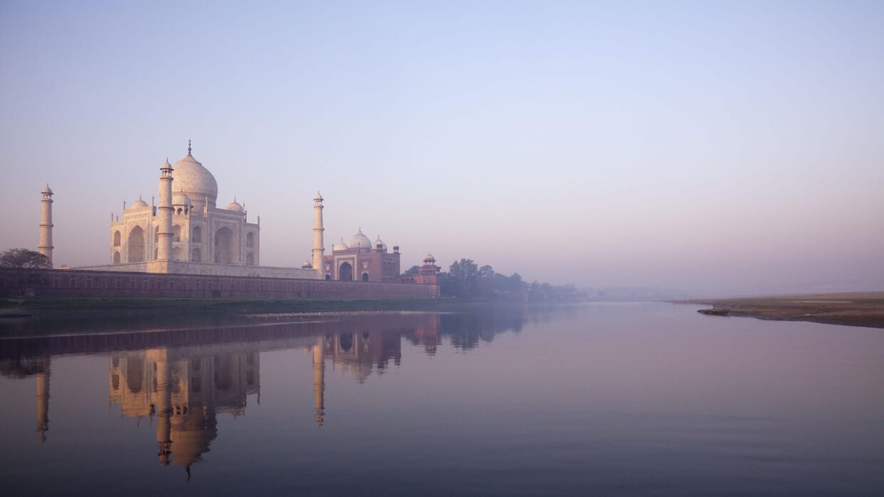 Det majestætiske Taj Mahal afspejles smukt i vandet.