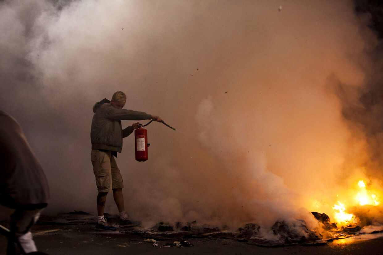 I 2011 tænder pushere brand i gaden efter en politirazzia. Christianitterne sørger for at slukke ilden.