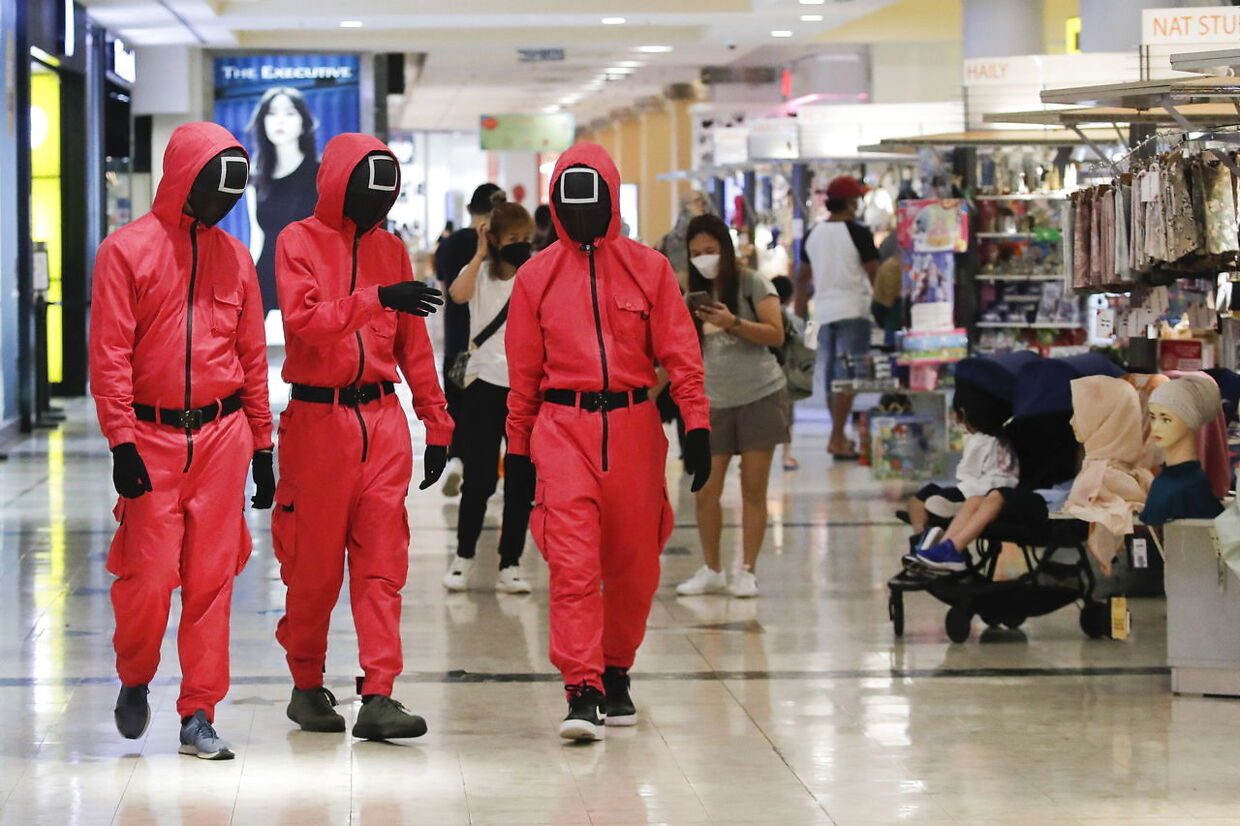 De lyserøde officerer fra Squid Game går rundt i et shoppingcenter i Kuala Lumpur, Malaysia.