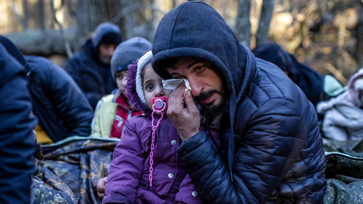 En irakisk migrant med sit barn ved grænsen mellem Hviderusland og Polen. Her har de ventet i ugevis.