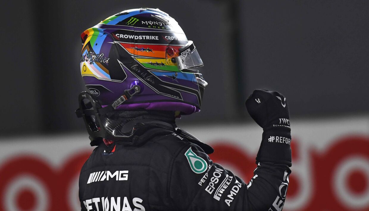 Lewis Hamilton - med regnbue-farvet hjelm til støtte for LBGT+-miljøet - fejrer sin pole position i Qatar.