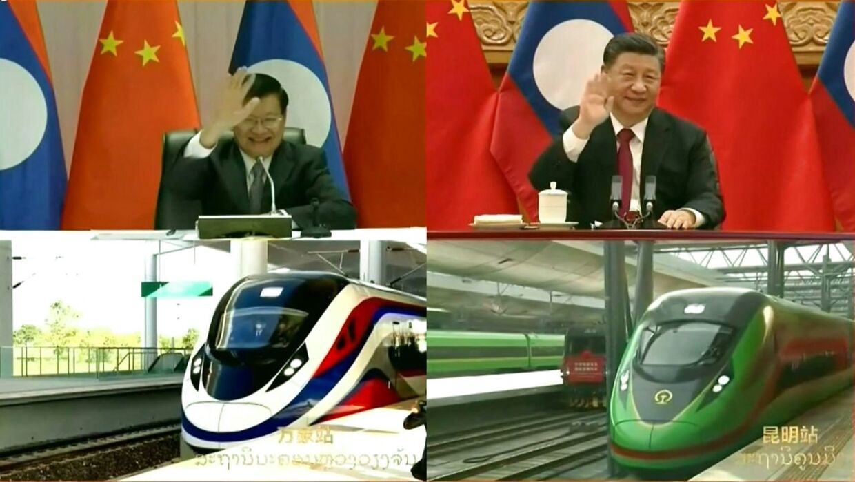 Laos præsident Thongloun Sisoulith (top tv) og Kina præsident Xi Jinping (top th.) vinker, da de virtuelt tager del i åbningen af den nye højhastighedsbane.