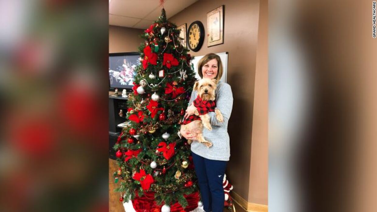 Jennifer Smith med hunden Boomer foran hendes store, velpyntede juletræ.