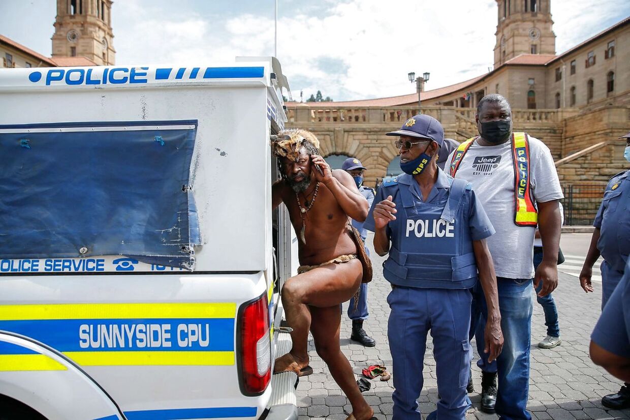 Kong Khoisan føres ind i politibilen, efter han er blevet anholdt.