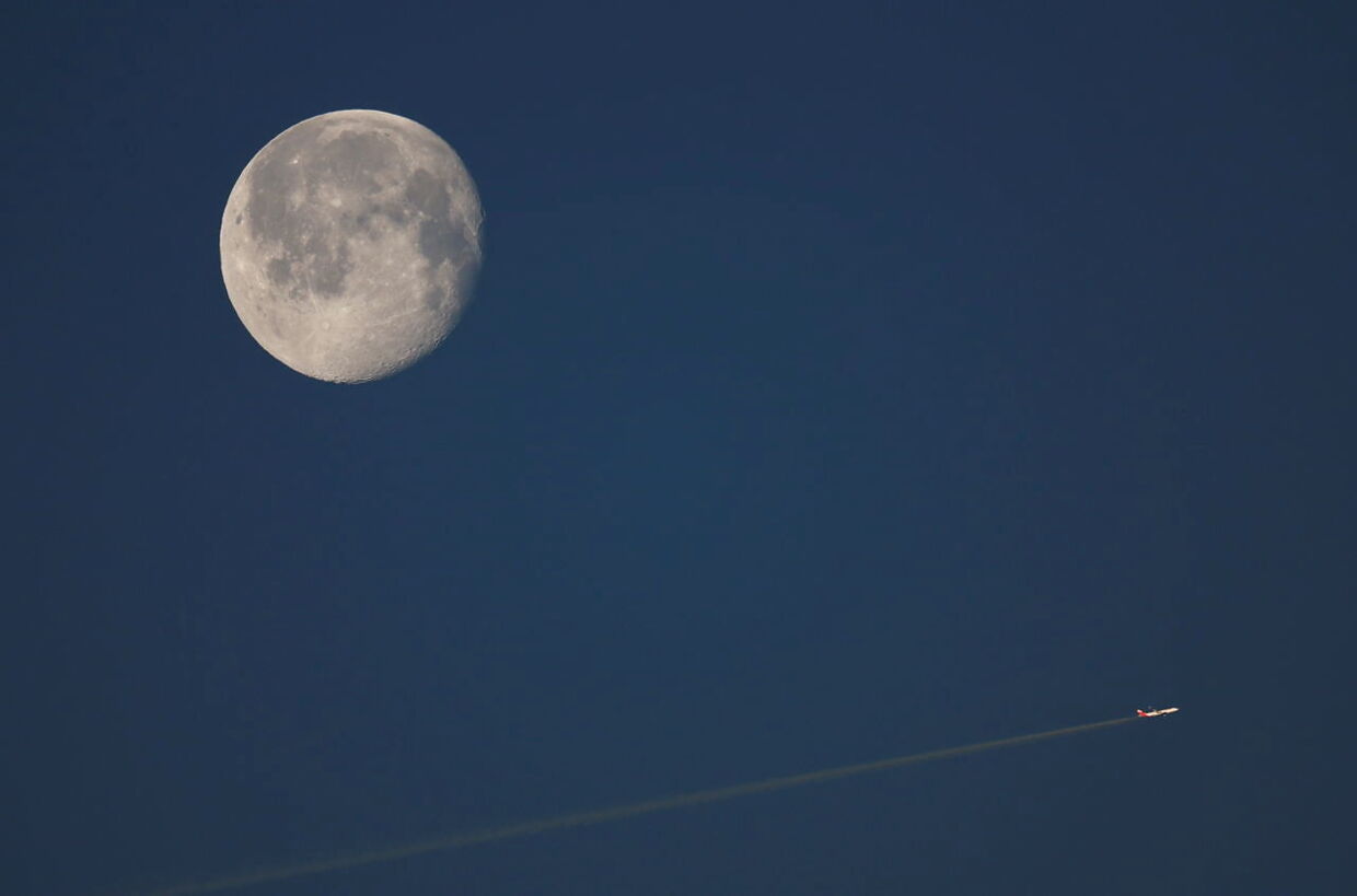 Et fly passerer Månen på himlen.