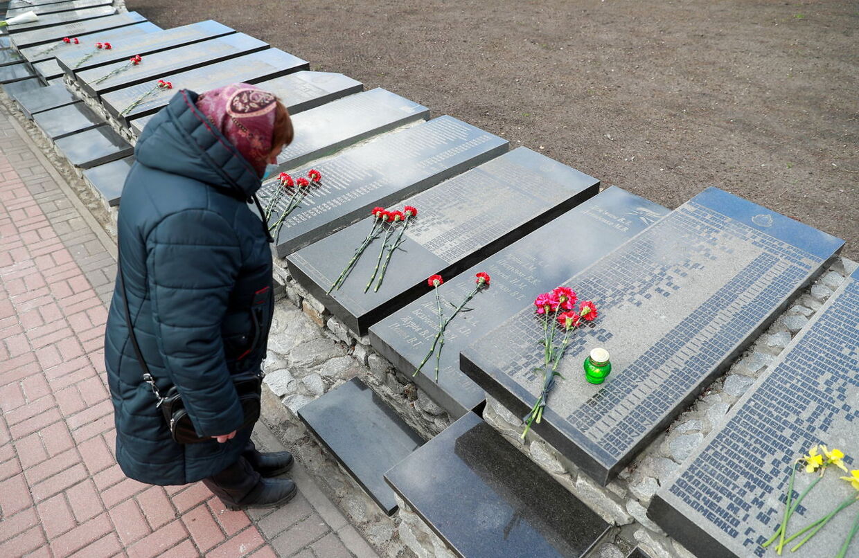 En kvinde lægger blomster på de dødes grave ved højtideligholdelsen af 35-året for atomkatastrofen i Tjernobyl.
