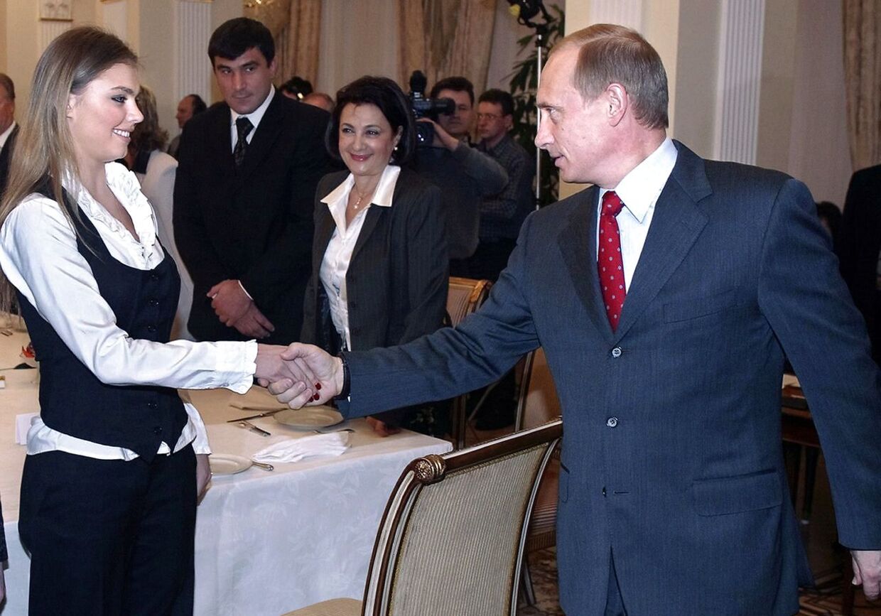 (FILES) A file picture taken on March 10, 2004, shows Russian President Vladimir Putin (R) shaking hands with Alina Kabayeva, Russian rhythmic gymnastics star and Olympic prize winner, during the meeting with sportsmen, candidates to Russian Olympic team for Olympics 2004, in the presidential residence in Novo-Ogaryovo outside Moscow. Russians reeled today from the shock announcement by President Vladimir Putin that his 30-year marriage was over, a break-up that was long an open secret but few imagined would ever be made public. The announcement unleashed speculation about whether Putin is seeing another woman, a subject that has so far been taboo. AFP PHOTO/ POOL /SERGEI CHIRIKOV