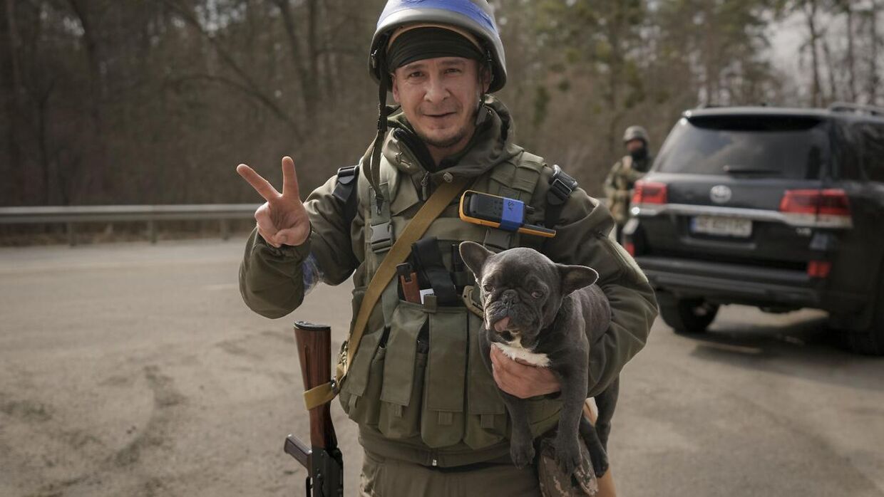 En ukrainske soldat bærer på en hund.