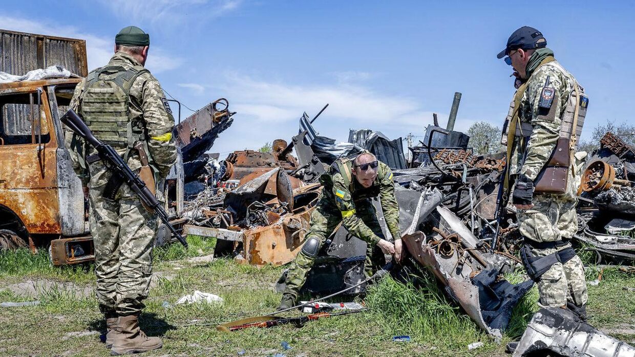 Ukrainske soldater leder efter stumper, de kan bruge, fra ødelagte russiske kampvogne i Butja uden for Kyiv. Her er de i gang med at skrue en antenne af et ødelagt køretøj.
