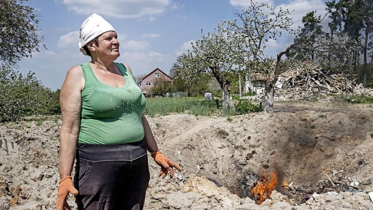 Maria på 62 står i en ruinbunke der engang var hendes hus i landsbyen Yasnohorodka. Russerne bombede i området, i et forsøg på et ramme en ukrainsk checkpoint, men knuste stedet Marias og naboens huse. Bag Maria ses et nedslagshul fra en russernes bomber.