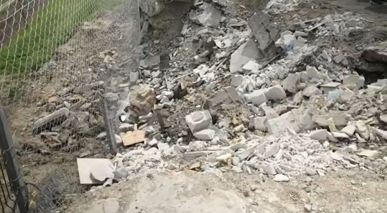 Et hul i jorden, som før var hvor værkstedets kontor lå. Her døde fire medarbejdere, da missilet ramte. Billede: CNN