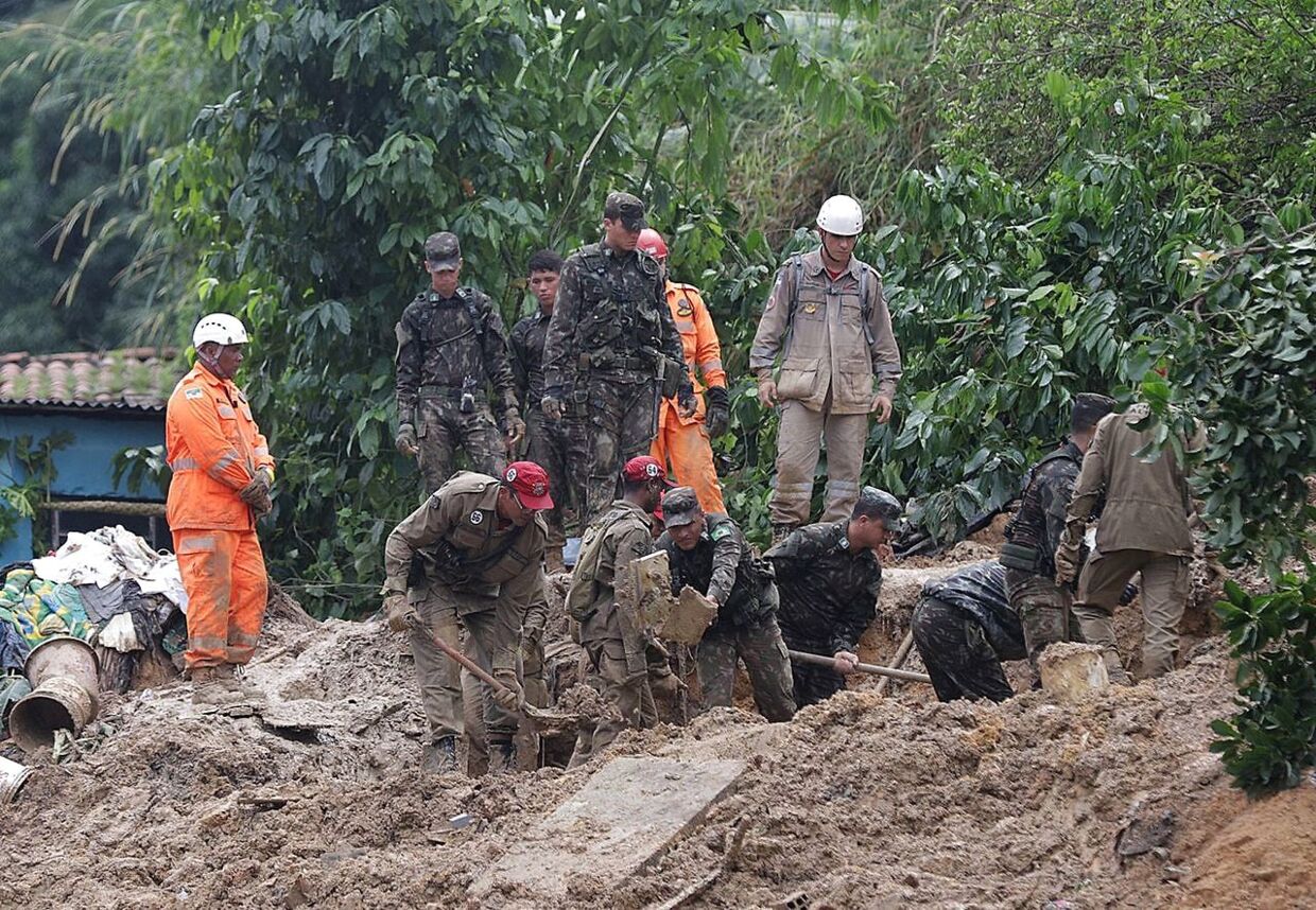 Redningsarbejdere graver i mudderet.