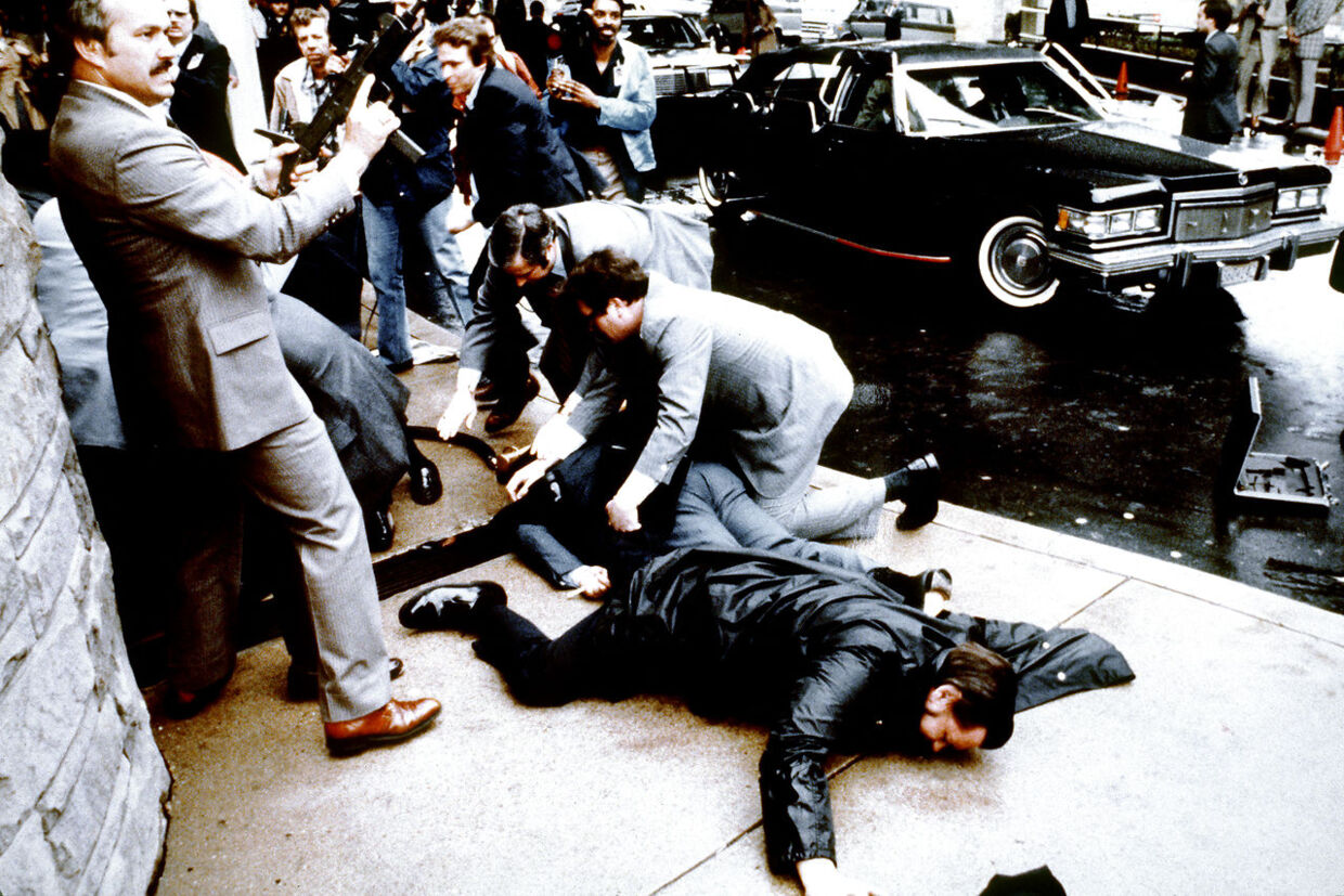 ARKIVFOTO fra 1981. Politiet og Secret Service ses her reagere, efter der er blevet affyret skud. På jorden ses politibejtenten Thomas Delahanty og pressechef James Brady ligge sårede.&nbsp; 