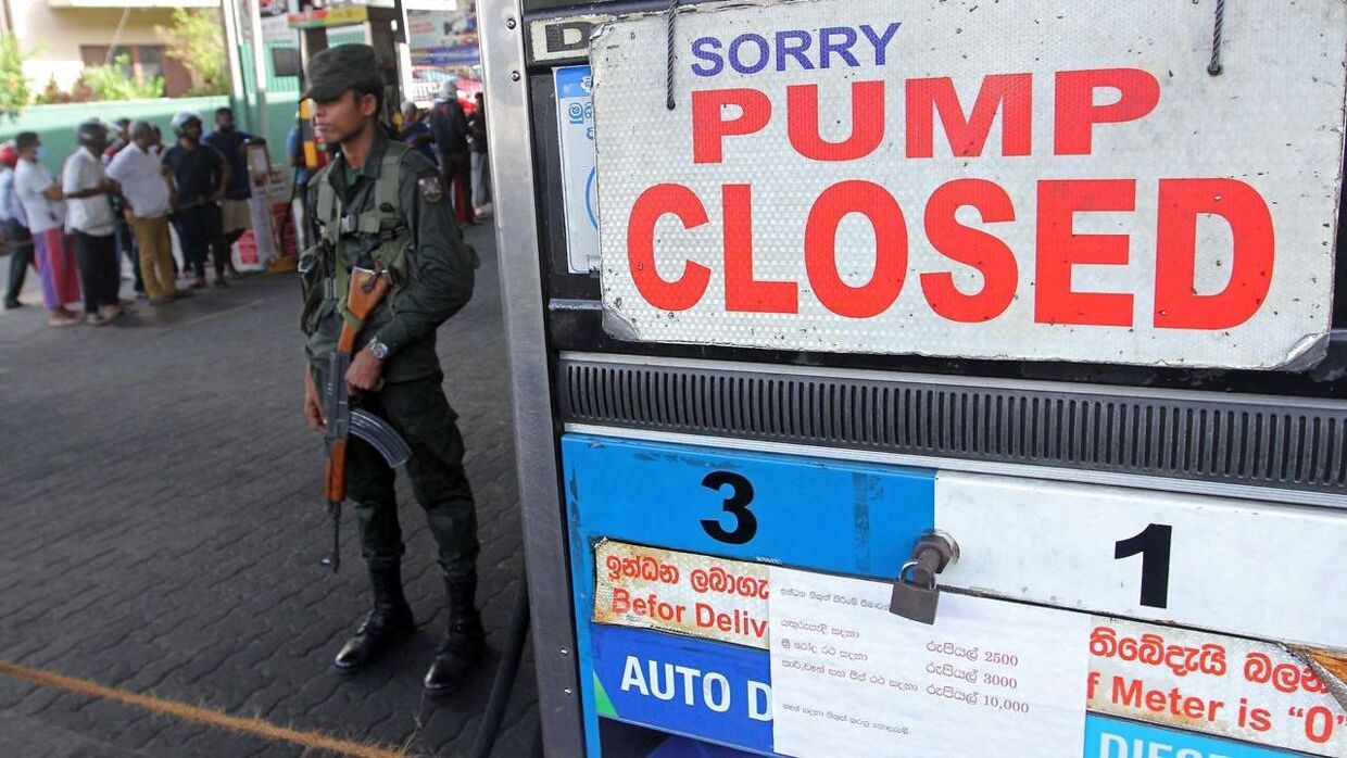 En bevæbnet mand fra Sri Lankas sikkerhedspoliti står vagt ved en benzinstation, der er lukket den 27. juni 2022.