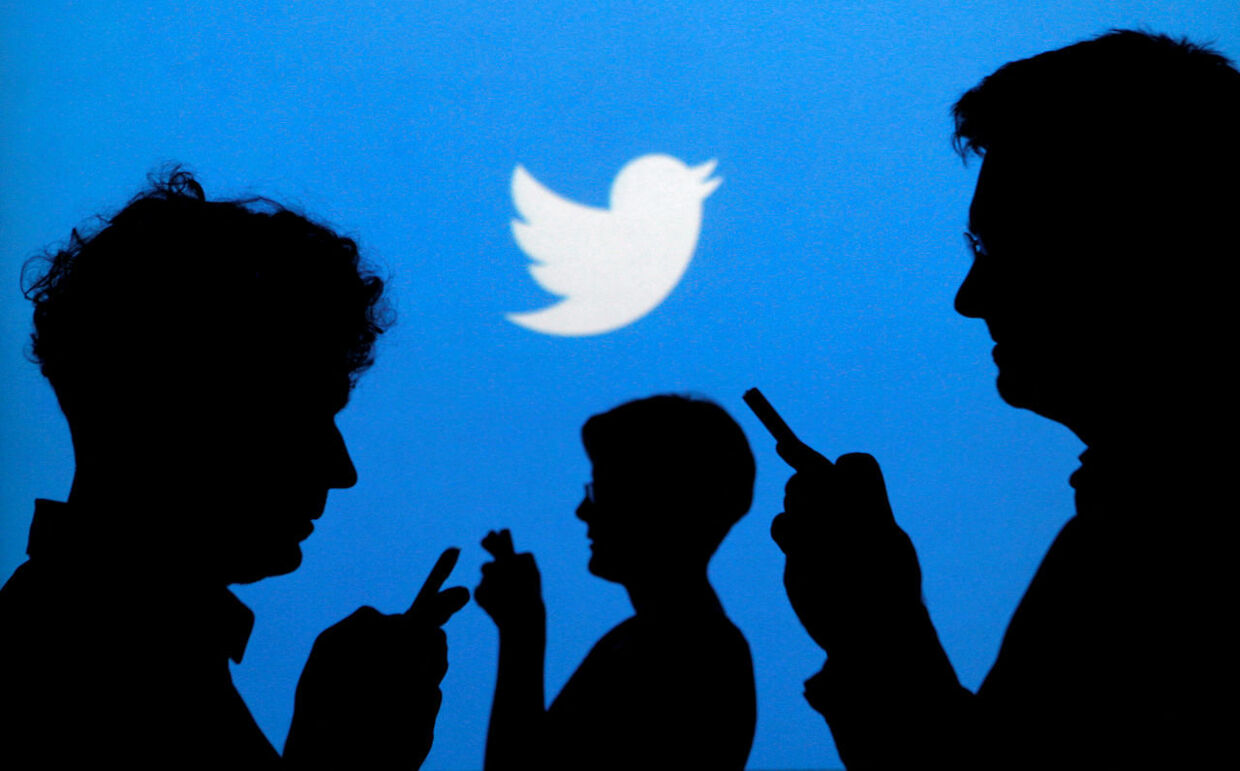 FILE PHOTO: People holding mobile phones are silhouetted against a backdrop projected with the Twitter logo in this illustration picture taken in Warsaw September 27, 2013. REUTERS/Kacper Pempel/File Photo