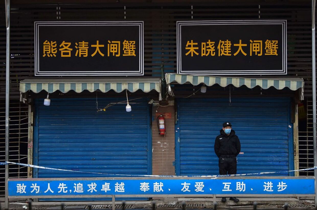 Dette foto er fra 24. januar 2020. Det viser en sikkerhedsmand stå uden for det lukkede Huanan Seafood Wholesale Market. Der blev coronavirussen først opdaget.