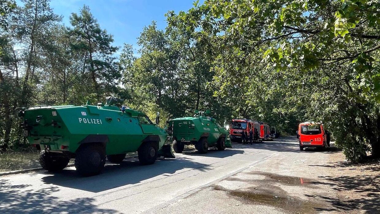 Køretøjer fra det tyske militær er til stede nær skoven.