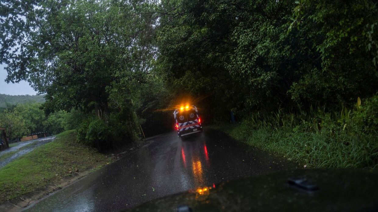 En ambulance kører ad en drivvåd vej i Puerto Rico.