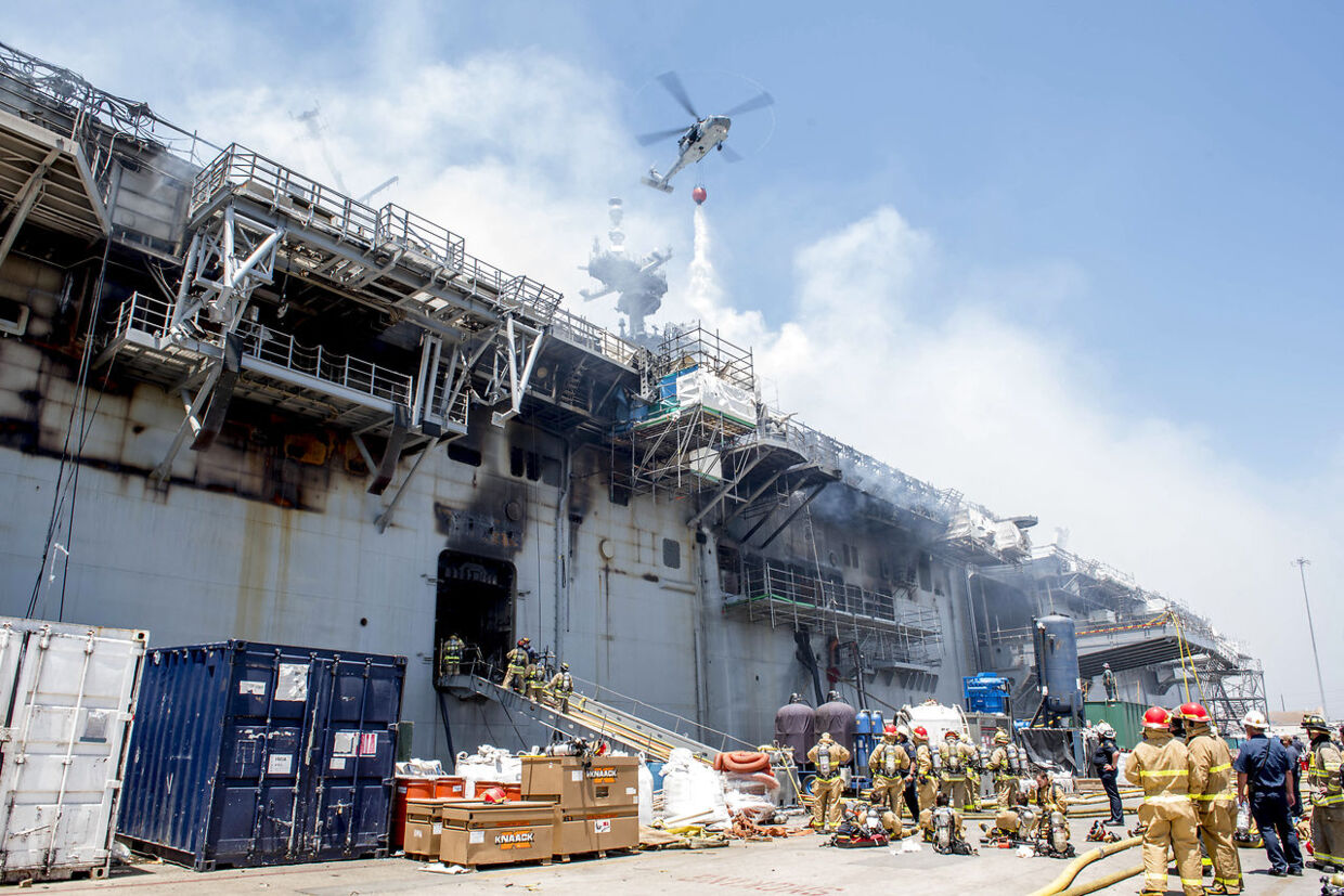 En helikopter bekæmper ilden på krigsskibet.