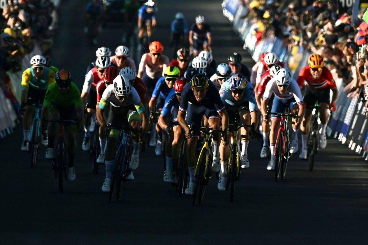 France's Christophe Laporte (C) reaches the finish line to come in second place in the men's road race cycling event at the UCI 2022 Road World Championship in Wollongong on September 25, 2022. (Photo by WILLIAM WEST / AFP) / - - IMAGE RESTRICTED TO EDITORIAL USE - STRICTLY NO COMMERCIAL USE - -