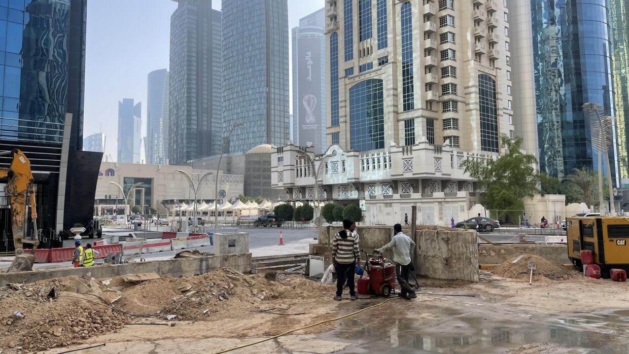 Migrantarbejdere i arbejde midt på dagen i heden i det centrale Doha.