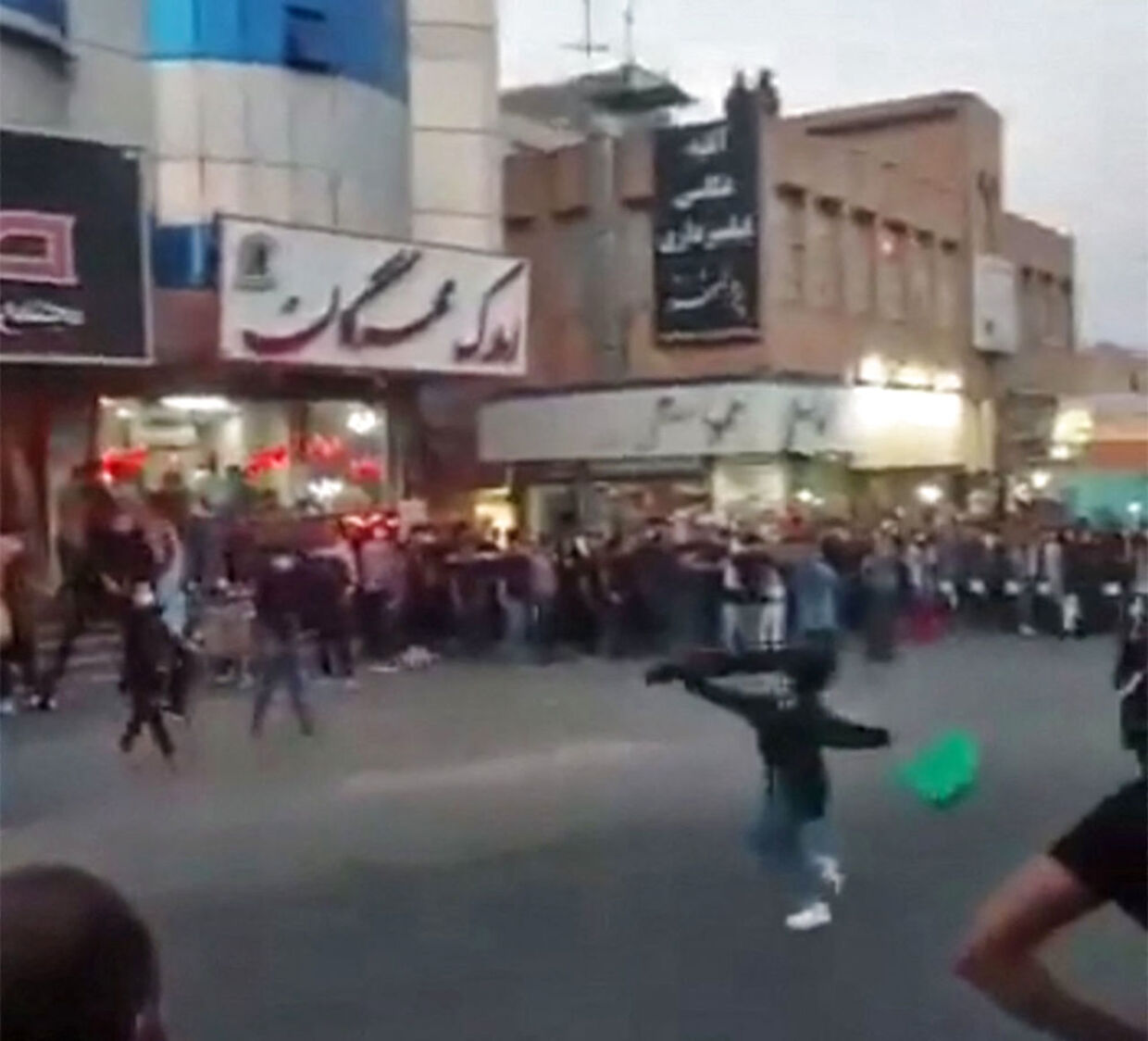 Dette lidt grynede billede er fra den iranske by Saveh. Det er taget 21. september og viser demonstranter lave en ring om en kvinde, der svinger sin hijab i luften. 