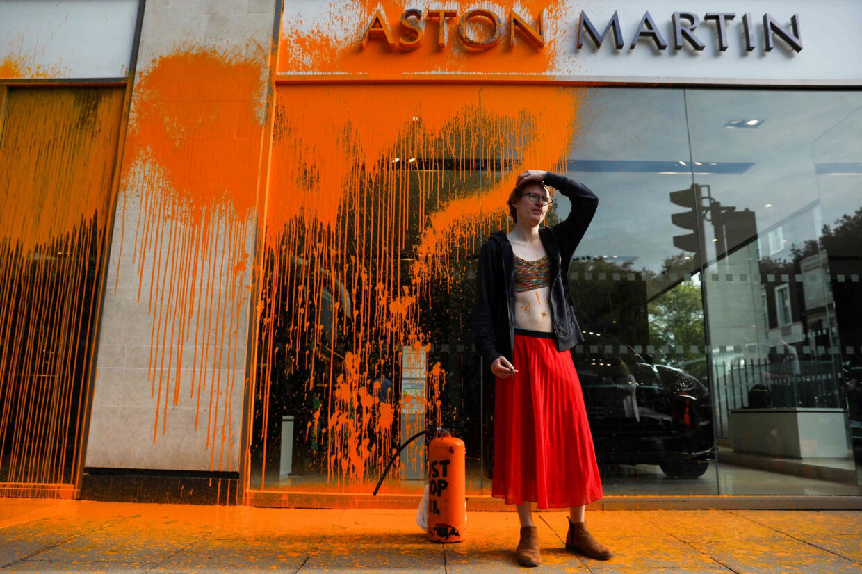 Et medlem af gruppen Just Stop Oil ses her søndag foran Aston Martins udstillingslokaler i det centrale London. Isabel Infantes/Ritzau Scanpix