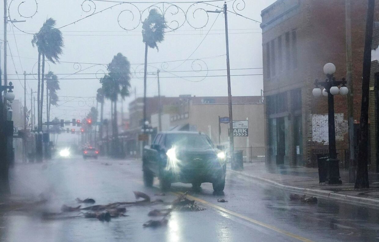 En pickup kører rundt om de faldende dele af et palmetræ i Ybor City i Tampa, Florida 28. september 2022.