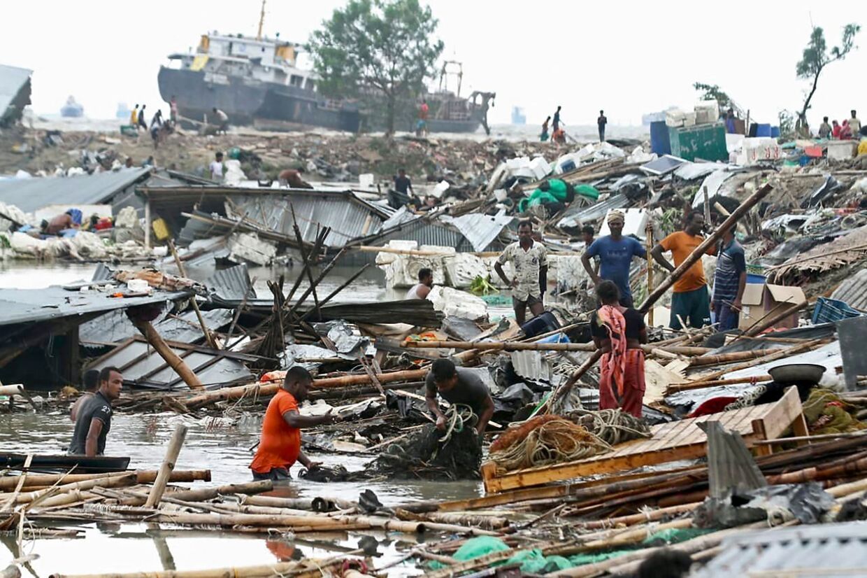 Indbyggere leder efter deres ejendele i de kollapsede hytter, efter cyklonen Sitrang har ramt Bangladesh.