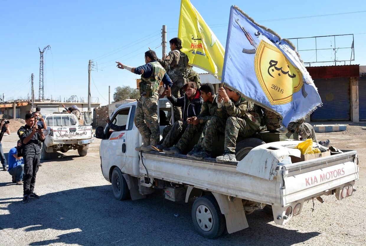 Kæmpere fra den Syrisk Demokratiske&nbsp; Forces (SDF) passerer Al-Na'im rundkørslen i det centrale Raqqa i Syrien den 18 oktober 2017. Rundkørslen blev brugt til henrettelser af ISIS og blev kendt som 'Rundkørslen fra Helvede'.