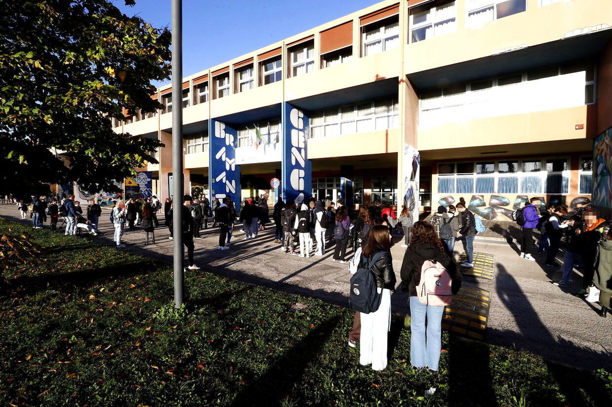 Lærere og elever står udenfor, efter at de har forladt klasseværelserne, da et jordskælv ramte ved Rimini, Italien.