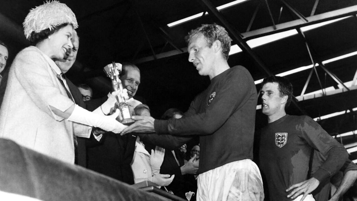 Afdøde dronning Elisabeth gav 30. juli 1966 den engelske anfører, Bobby Moore, og målscoreren Geoff Hurst (th.) trofæet på Wembley efter finalesejren på 4-2 over Vesttyskland.